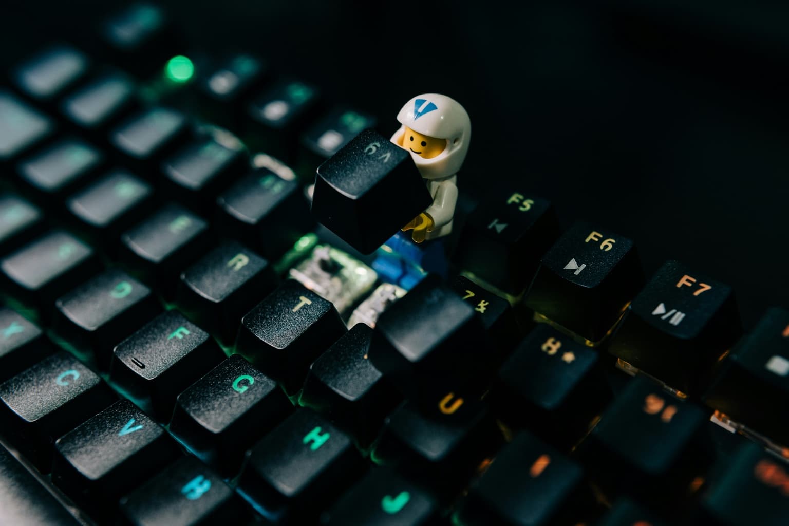 Mechanical keyboard with keycaps removed and a LEGO figure lifting a switch