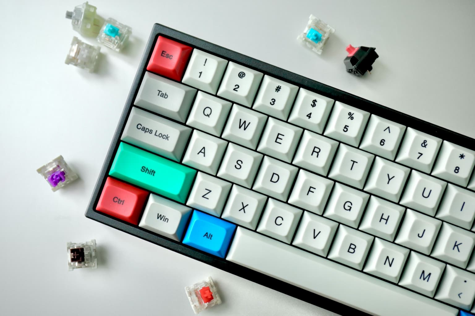Compact mechanical keyboard with colorful keycaps and loose switch samples around it